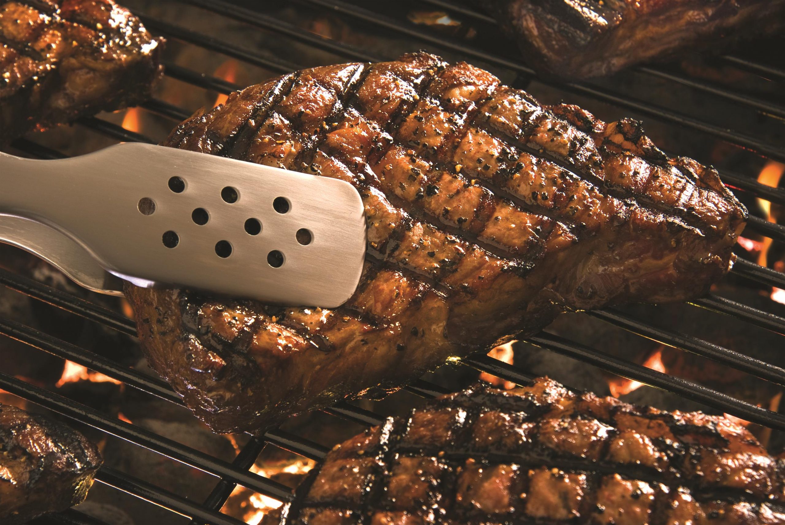 Flipping a steak on the grill